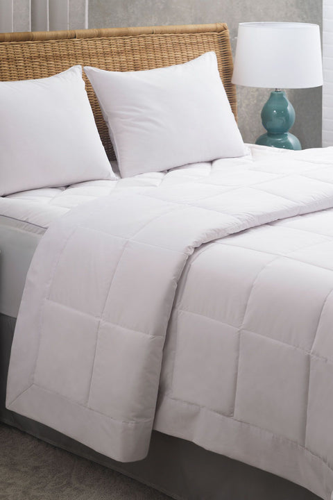 PureAssure Allergen Barrier Deluxe Blanket laying on the bed and folded over about halfway down the bed. Squares stitched into the blanket.