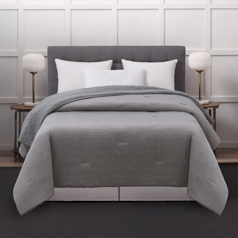 The Reversible Cooling Sherpa Blanket displayed on a fully made bed, Sherpa side down, cooling side of the blanket up.