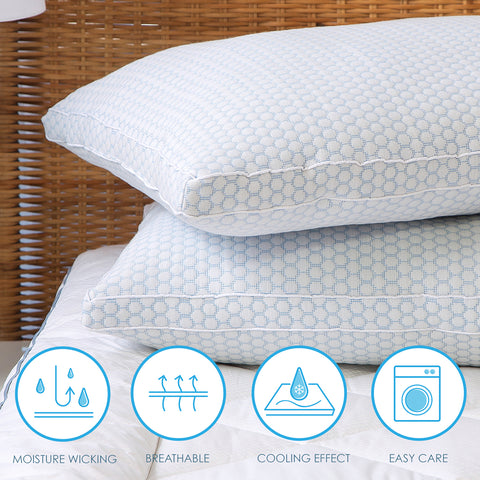 Two CoolMax pillows stacked atop one another. The top pillow slightly askew. The photo focusing on the left sides of the pillow, getting  aside view of the longer side of the pillows. The pillow features a distinctive white and blue dotted pattern on the pillows. On the bottom of the image there are four white circles with blue outlines. In each circle there are different images representing different features of the pillow. Moisture Wicking, Breathable, Cooling Effect, & Easy Care.
