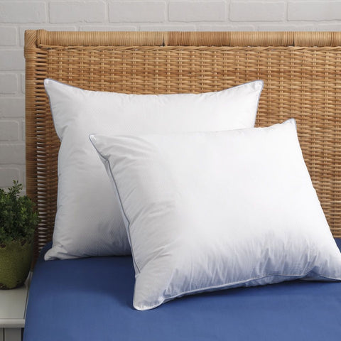 Two Down-Alternative Cooling Pillows. One standing tall against a wicker head board and the other leaning on the ride side of the pillow on an angle. Crafted from 100% cotton and enhanced with innovative Phase Change Material (PCM) 