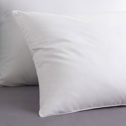 Two PureAssure Allergen Barrier Down Alternative Pillows leaning on one another atop a white base. The image is zoomed in so you can't see a background. The front pillow seems to have a light shining on it to make the front pillow pop.
