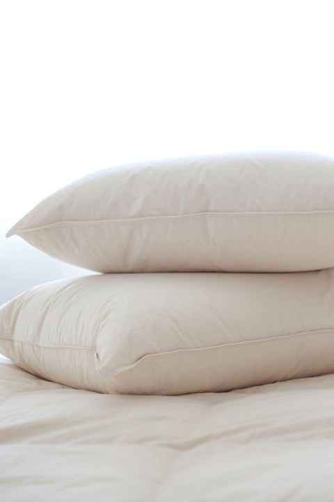 Organic Cotton Down-Free Pillow made with 100% organic cotton, this 233 Thread Count. Two pillows in the picture laying on top of each other, they're white with a pinkish hue.