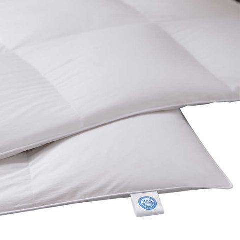A really close up image of the corner of the comforter, emphasizing the RDS certified tag. This exquisite comforter features a 400 thread count sateen cotton fabric that is intricately woven to create a down-proof barrier. This ensures that the premium high loft 700 fill power white down is securely contained within.
Designed to offer optimum loft and even distribution, this comforter boasts a baffle box construction with a 1" gusset.