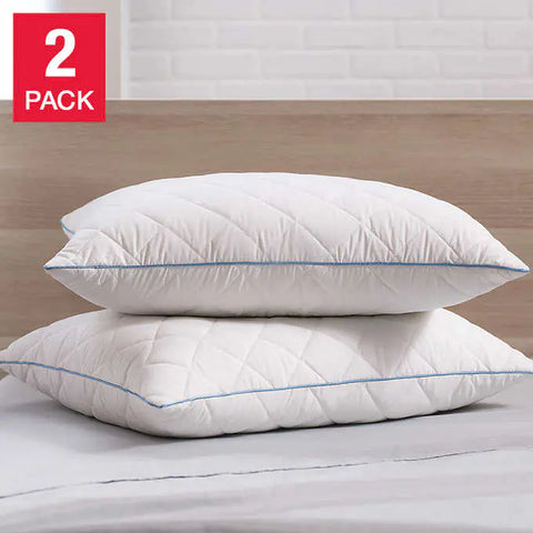 Two pillows with diamond shapes on them and blue stitching along the sides, lay on top of one another. The top pillow is straight while the bottom pillow is slightly skewed. Crafted with a 300 thread count cotton cover infused with temperature-regulating ClimaRest®, these pillows are also quilted with Suprelle® Cool Night gel fiber for effective heat dissipation. Brown head board faded in the background. A red sticker on the corner of the image saying that it is a two pack.