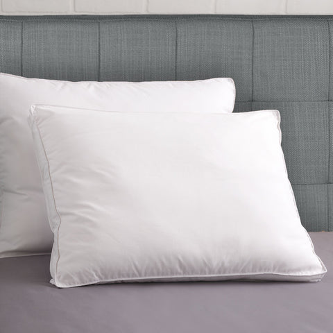Two PureShield Gusset Pillows, one leaning on a grey headboard while the other pillow leans on the intial pillow. The pillows are white.