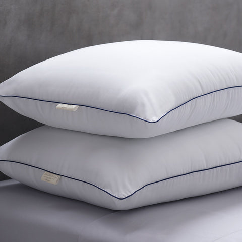 Two Cozy Clouds Microfiber Pillows laying perfectly on top of each other. Both with a dark line going along the side of the pillows and a white tag sticking out.