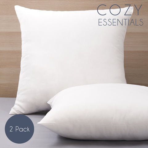 Two Cozy Clouds Cloud9 Euro Dream Pillows one sitting perfectly straight on the headboard and the other laying flat in front of the first pillow. Both pillows are perfect white squares. On the top right of the image is the words "Cozy Essentials" in blue text. On the bottom left corner of the image is a blue circle with white text that says "2 Pack."