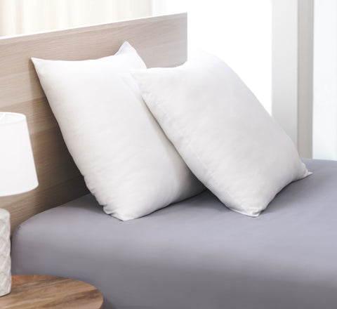 Two Cozy Clouds Cloud9 Euro Dream Pillows, one leaning headboard and the other leaning on the first pillow. Both pillows are perfect white squares. 