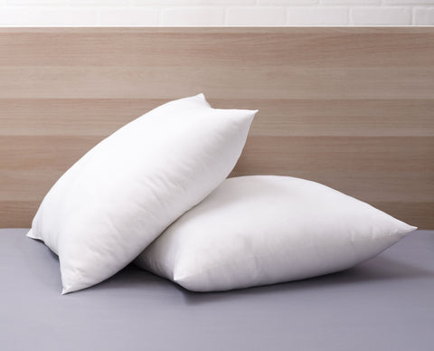 Two Cozy Clouds Cloud9 Euro Dream Pillows Laying atop one another both askew. The pillow on top is almost sitting up right but leaning on the flat pillow for support. Both pillows are perfect white squares. 