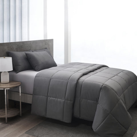 The Graphene Comforter aka the CharcoBlanket, is shown laying on a bed generously folded over itself at the top. With 420 thread count cover fabric. Large squares stitching running across the whole surface.