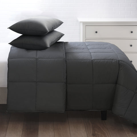 The Graphene Duvet aka the CharcoComforter, is shown laying on a bed generously folded over itself at the top. With 420 thread count cover fabric. Large squares stitching running across the whole surface.