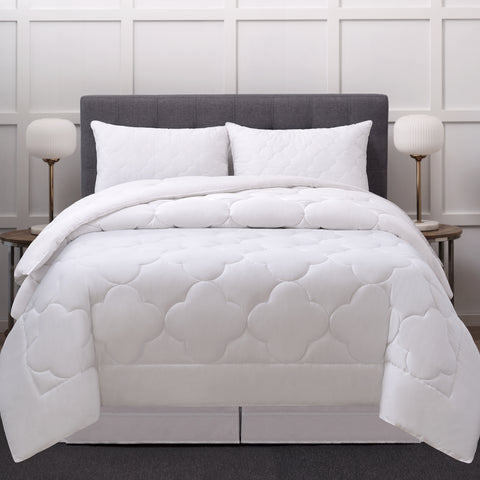 A bed with pillows on a headboard. In front of the pillows is a comforter with 8 inch frame with a 10 to 13 inch quilted cloud pattern in the center and is filled with high-quality, gel-fiber polyester filling with a 300 thread count cotton.