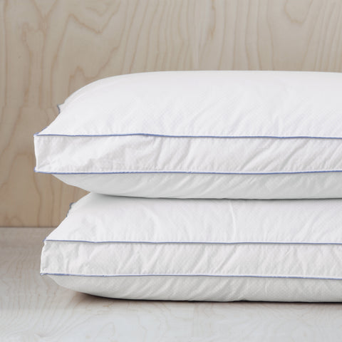 Two Climarest Cooling Gusset Pillows stacked atop one another. All white except there are two stripes parallels to one another and it kind of gives the allusion of creating a rectangle across the sides of the pillow without actually having connecting lines.