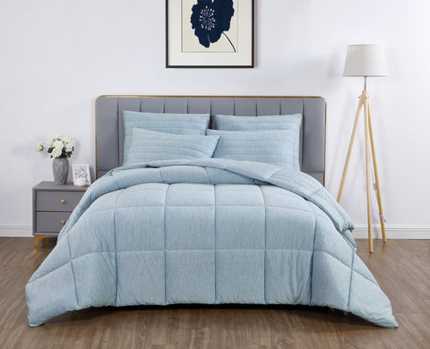 On the top of the image is a picture frame with a photo of a navy flower. On the left of the image is a grey nightstand with zebra printed flower vase contained white flowers. On the right of the image is a lamp, with three wooden legs and a white lamp shade. A bed in center frame. There is a grey headboard with multiple pairs of long rectangle on top of one another going across the headboard. Four baby blue pillows leaning on the headboard, with a beautiful fluffy baby blue comforter/blanket.