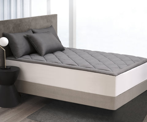 The Graphene Mattress Pad aka the CharcoMattressPad, is shown with matching pillows laying on the bed. With 420 thread count cover fabric. Large diamonds stitching running across the whole surface.