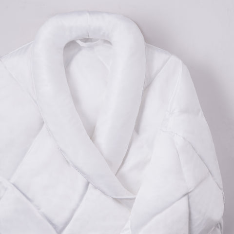 A zoomed in image of the top part of the plush Satin Puffer Robe being displayed here on a white background. With a little loop at the neck for your hanging pleasures. Diamond shaped stitching across the whole thing. Hoodless. White elegant, hotel styled robe.