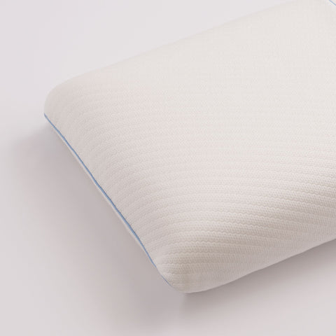 Image of the pillow on a white surface. Mini square stitching all across the surface. The pillow it white with a blue line around the sides.