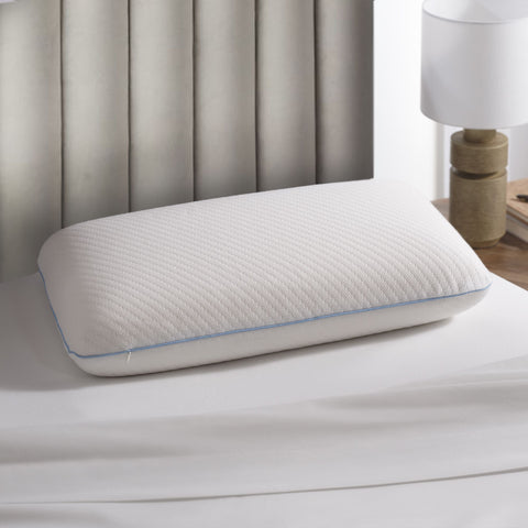 On a bed with a grey headboard, lay a pillow. The pillow is laying flat and you see the single blue line around the side of the pillow and can see the small square stitching across the top of the pillow.