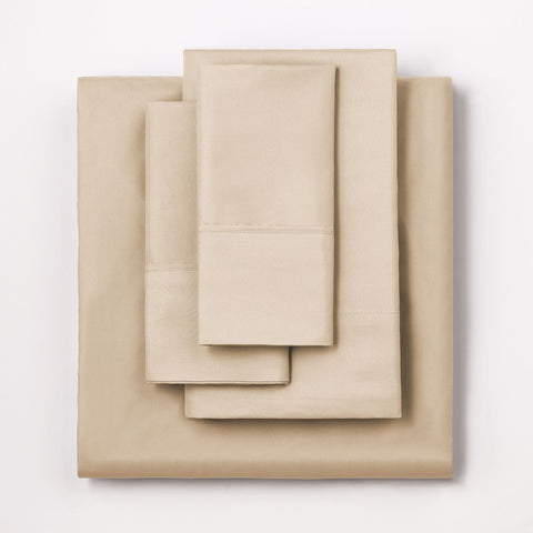 On a white background we have a full set of the Oat colored Microfiber Sheet Set. All perfectly folded up and layered on top of each other.