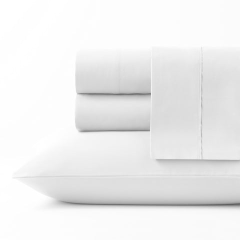 On a white background we have a full set of the White colored Microfiber Sheet Set. All perfectly folded up and layered on top of each other. Getting a side view of the pile this time and on the bottom of the pile is a pillow inside the white colored pillow case.