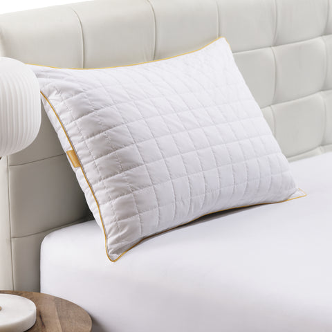 Pillow laying on white headrest. Squares stitching across the surface over the pillow. Classic Simmon's Yellow line around the ends and a matching yellow Simmons tag on the left side. 230 thread count quilted cover.