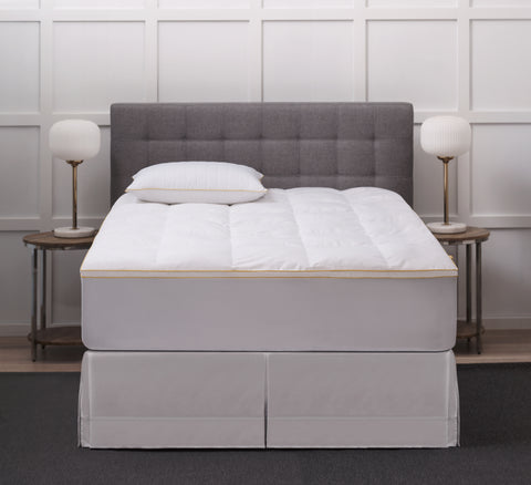 Poly Prime Feather Fiber Fill Bed displayed on a bed you can see the classic Simmons's yellow stitching with a matching Simmons' pillow on the bed.