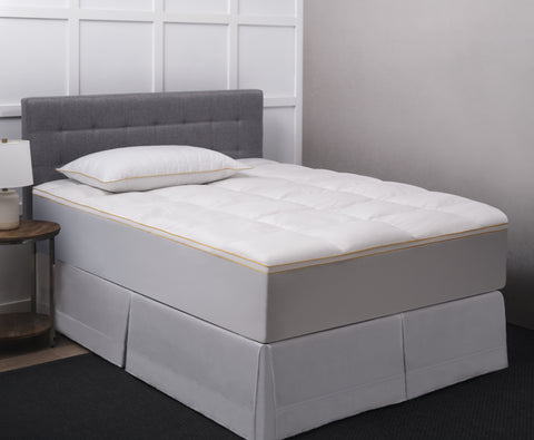 Poly Prime Feather Fiber Fill Bed displayed on a bed you can see the classic Simmons's yellow stitching with a matching Simmons' pillow on the bed.
