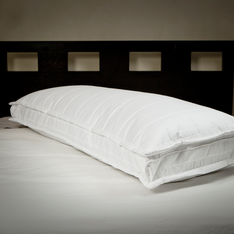 The Quilted Full Body Pillow is displayed here. The pillow is white is long. It has square stitching along the top and bottom of the pillow. The sides have no design, but the stitching creates what looks like a rectangle, that wraps around the pillow.