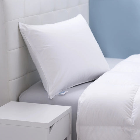 Zoomed in image of a bed, where you can only see the head of the bed. There is a pillow leaning on a white head board at a bit of angle, with a little tag sticking out saying it is RDS ceritfied. 400 thread count sateen cotton zipper removable cover that allows for easy care. The inner cover is a 233 thread count cotton that is woven tightly to create a down-proof barrier that ensures the high loft 650 fill power white goose down stays inside.