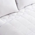 Climarest Cooling Comforter laying on a bed with a blue line around the perimeter of the comforter. Squares running up and down the entirety of the comforter.
