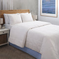 Climarest Cooling Comforter laying on a bed with a blue line around the perimeter of the comforter. Squares running up and down the entirety of the comforter.