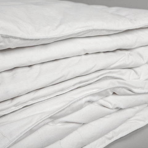 Zoomed in photo of a comforter folded up, the image emphasizes the many folds in the blanket.  The 100% cotton cover is made with a 233-thread count that makes for a soft and extremely durable comforter. 
