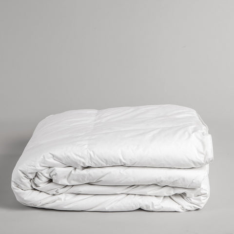 A white background. In the bottom have of the picture, is our basic down alternative comforter, folded in a perfect square. We are getting a side view of the item.  The 100% cotton cover is made with a 233-thread count that makes for a soft and extremely durable comforter. 