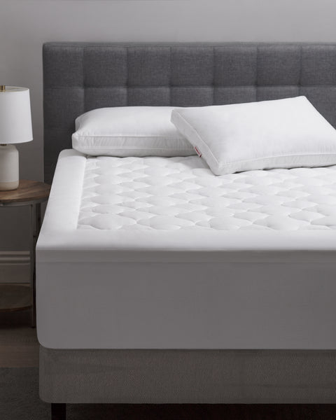 Foot of the bed shot of a Billow Mattress pad, a thick 300-Thread Count cover and Gel Fiber Poly fill.