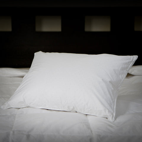 On a bed is the Perfect White Goose Down Pillow - 50/50 Fill - Medium Plush Support leaning back and to the side.