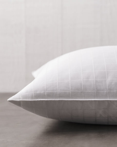 Plush Perfect Gel Fiber Pillow (Medium) (Set of 2), only one of the pillows is pictured here. We get a side angle of half the pillow. The white pillow has small little squares going all across it.