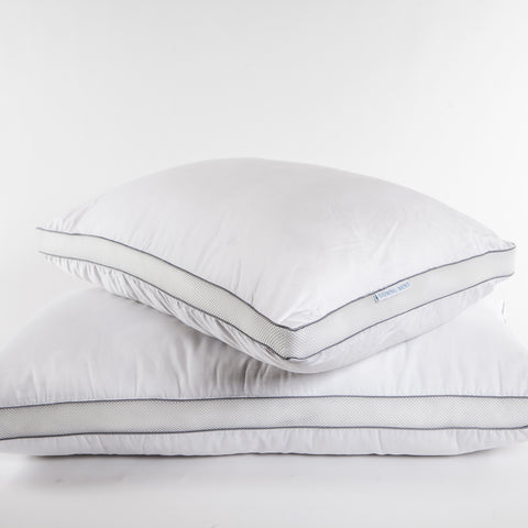 PowerNap Celliant Fiber Blend Pillow (Soft) (Set of 2). One pillow laying perfectly straight with another on top askew. The pillows are white with two blue parallels lines going along the sides of the pillows.