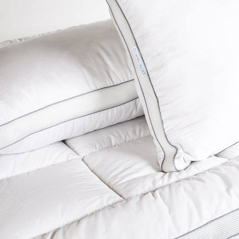 PowerNap Celliant Fiber Blend Mattress Pad can see the large squares on the surface. There are some pillows on top to create the scene.