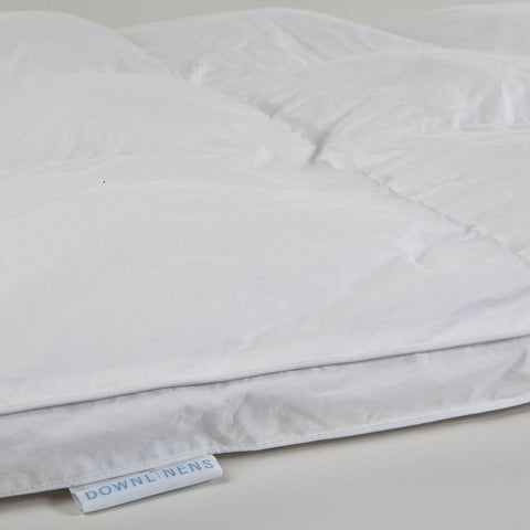 Corner of the 100% cotton with a 300-thread count and a soft cluster fiber fill. With white mini tag sticking out with "DOWNLINENES" written in blue letters.