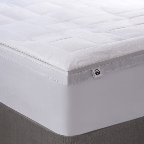Corner image of Luxury Down Feather Bed - RDS Certified with a little RDS certified tag sticking out. Square patter all over the top of the bed and the side are completely solid white.