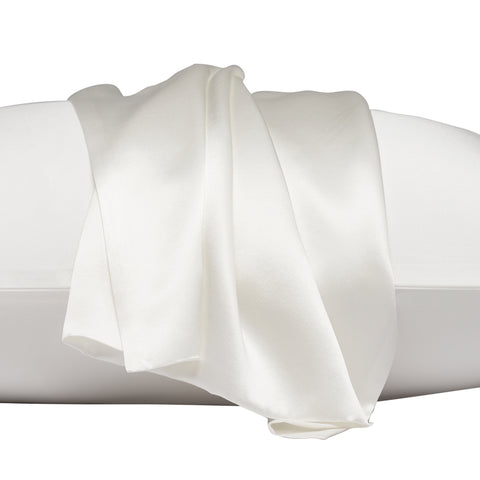 On a white background is a pillow laying flat. The pillow is in the ivory silk pillow case, with another ivory pillow case on the center of the pillow, overlapping on itself. This image is almost trying to emphasize the pillowcase that's resting on top, by zooming in.