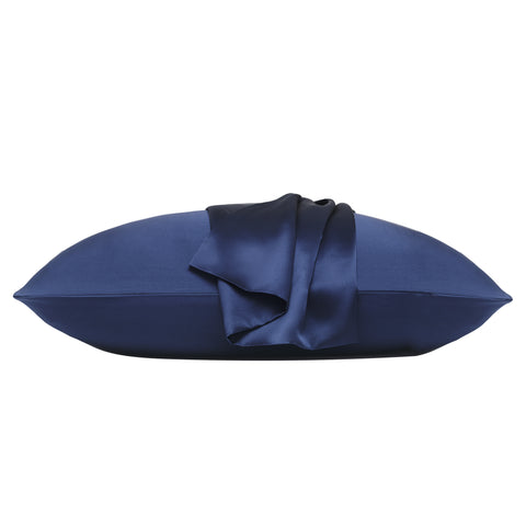 On a white background is a pillow laying flat. The pillow is in the navy silk pillow case, with another navy pillow case on the center of the pillow, overlapping on itself.