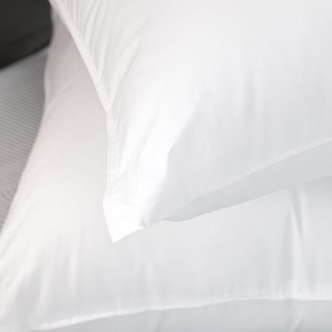 Image of the corner of a pillow that is laying atop another pillow. Sleep Protection pillows utilize MicronOne fabric technology, creating a clean barrier between you and potential microtoxins that build up naturally over time in every pillow.