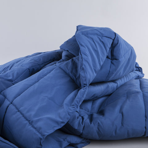 Nautical Blue Peachy Down Alternative Comforter clumped up and you can see that there is square stitching running up and down the blanket. 